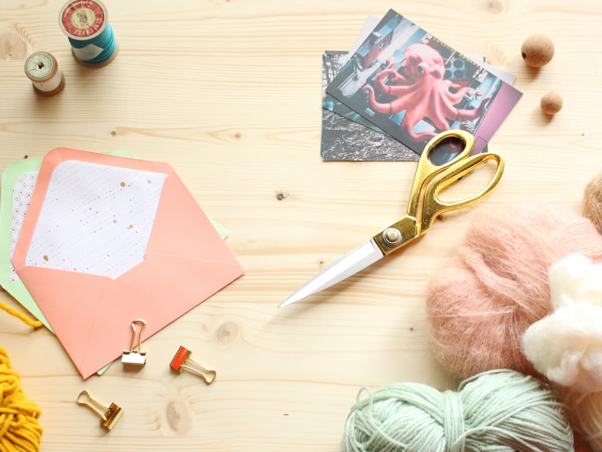 Craft table with envelopes, scissors, yarn, and thread